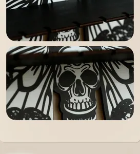 Detailed view of moth-shaped wooden shelf with gothic skull pattern and black engravings