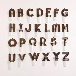 Macro view of alphabet shaped wooden wall planters with clear glass test tube vases