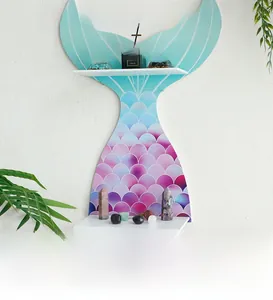 Detail view of mermaid tail wooden wall shelf with teal fish scale texture and white tiers