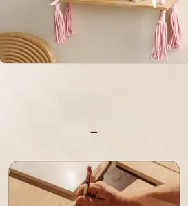Detailed close-up showing the smooth texture of the handmade wood shelf with pink tassels