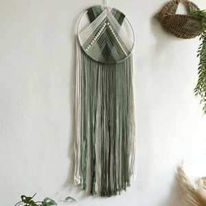 Detail view of handmade macrame wall hanging with forest green cotton ropes and wood beads