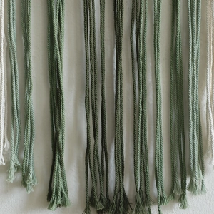 Detailed macro view of bohemian hand-woven cotton ropes with green and cream tassels