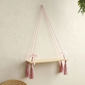 Pink macramé wall hanging shelf with wooden beads and tassels for home decor