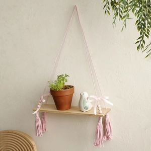 Handmade woven macrame plant shelf with wooden beads and pink tassels for wall decor