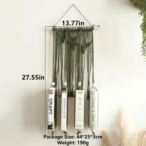Detail of green handmade macrame book holder with cotton fringe and wooden beam