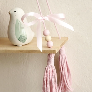 Handmade woven wood shelf with pink cotton ropes, tassels, and a silk bow for wall decor