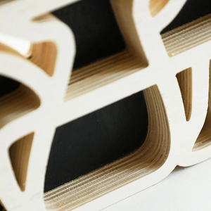 Close-up of laser-cut multilayer plywood texture and smooth edges on mushroom shelf