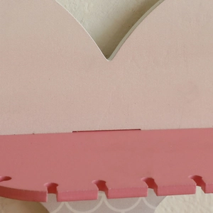 Close-up detail of pink wooden fishtail shelf showing smooth matte finish and assembly slots