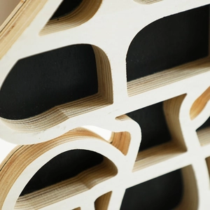 Macro shot of tiered plywood edges and matte black finish on mushroom shaped wooden shelf