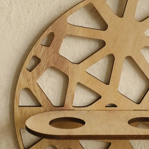 Detailed view of bohemian wooden shelf showing laser-cut geometry and natural grain texture