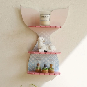 Detail of wooden mermaid tail shelf with blue scales and pink tiered display platforms