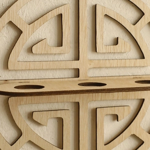 Detail of laser-cut geometric pattern on bohemian wooden shelf with natural wood grain
