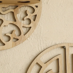 Detail of bohemian round wooden shelf showing intricate hollow carving and natural wood grain