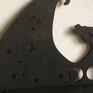 Detail of laser-cut wooden dragon shelf showing moon phases and celestial starry patterns