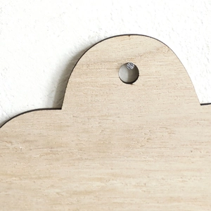 Détail du vase en bois clair en forme de nuage montrant le grain et le clou de fixation