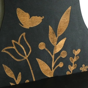 Detailed close-up of intricate butterfly and tulip wood carvings on a black cat shelf