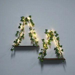 Macro view of wooden wall shelf with green ivy vines and warm glowing LED fairy lights
