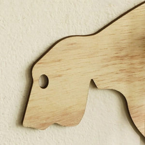 Macro view of natural wood texture and laser-cut edges on animal shaped wall planter