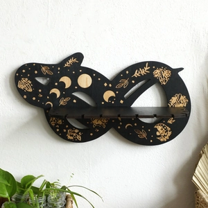 Détail de l'étagère murale en bois en forme de serpent avec gravures de phases de lune