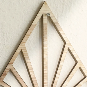 Detailed laser-cut texture of fan-shaped wooden wall planter with geometric line patterns