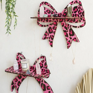 Detail of pink leopard print wooden bow shelves showing necklace hanging slots