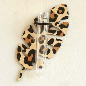 Detail of leaf-shaped wooden propagation station with leopard print and glass test tube