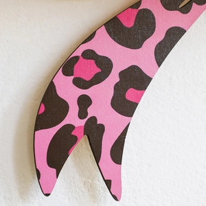 Detailed close-up of pink and black leopard print wooden shelf with matte texture finish