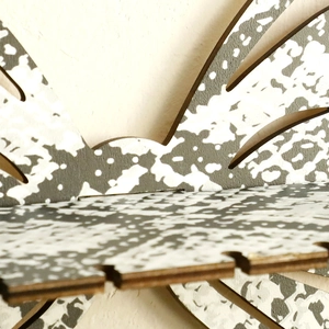 Detail view of the bohemian laser-cut plywood butterfly wall shelf with black and white patterns