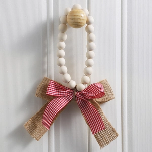 Detail of wooden bead wreath featuring a rustic burlap and red checkered bow decoration