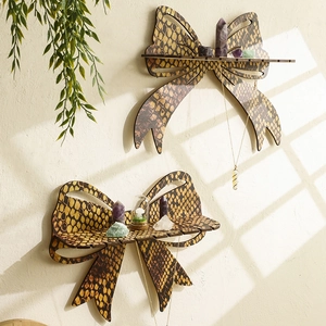Golden bow-shaped wooden wall shelf set with reptile texture in a sunlit bedroom