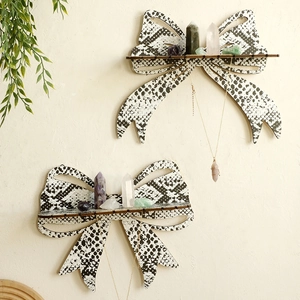 Detail of wooden bow-shaped wall shelves with snake pattern for crystal and jewelry storage