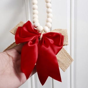 Macro detail of natural linen bow and red satin ribbon with wood beads wall decor