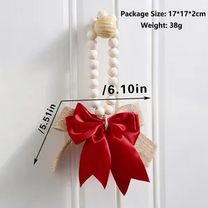 Detail view of rustic wall decor featuring wooden beads and a large red ribbon bow