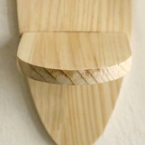 Detailed view of the natural wood grain on an oval wall-mounted floating shelf