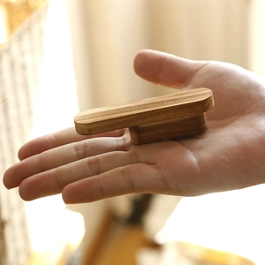 Close-up showing the size and natural wood grain of the T-shaped wooden furniture handle