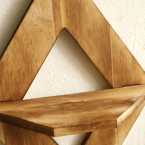 Primer plano de estante de pared de madera en forma de rombo con texturas naturales oscuras
