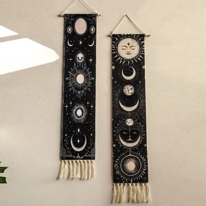 Detail of bohemian sun and moon woven tapestries with mystic symbols and ivory tassels