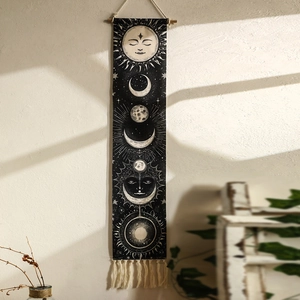 Detail showing the sun and moon phase printed patterns with elegant tassels on a tapestry