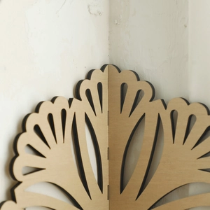Detail of wooden flower petal corner shelf showing precise laser cut edges and texture