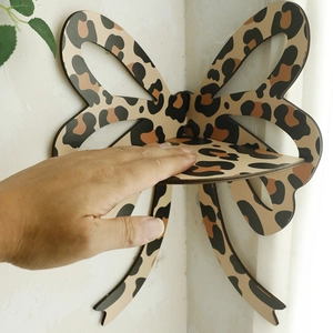Detail view of a bohemian bow-shaped wooden corner shelf featuring a trendy leopard print pattern