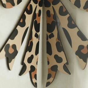 Detail of bohemian wood craft showing leopard print pattern on a fan-shaped wall shelf