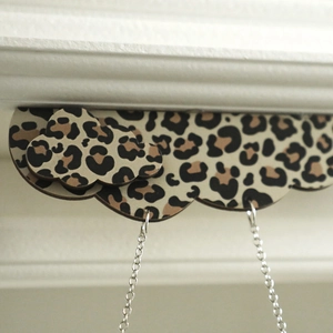 Close-up of cloud-shaped leopard print wooden pendant with silver metal chains