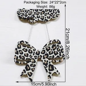 Close-up of wooden leopard print bow pendant with decorative cloud hanging board