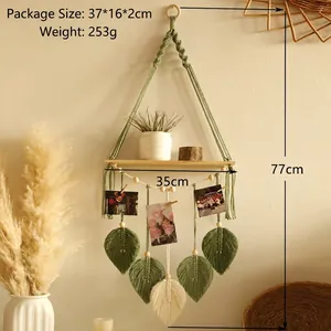 Detail of bohemian woven macrame wall shelf with leaf patterns and small wooden photo clips