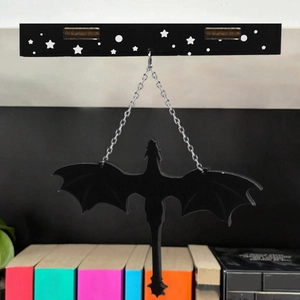 Detail showing a black dragon hanging ornament with silver chain for home decoration