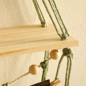 Detail of bohemian woven cotton rope knots and natural wood shelf texture