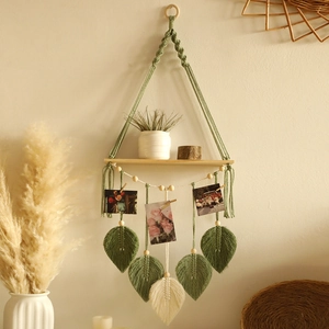 Detail of bohemian hand-woven shelf with leaf tassels and wood beads for wall decor