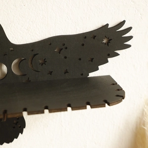 Macro detail of eagle-shaped wooden shelf with moon and star hollow-out patterns