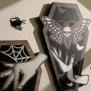 Gothic coffin-shaped wood wall decor featuring skull moth and spider web patterns