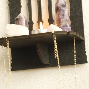 Close-up of black gothic wood floating shelf for crystal display and necklace hanging
